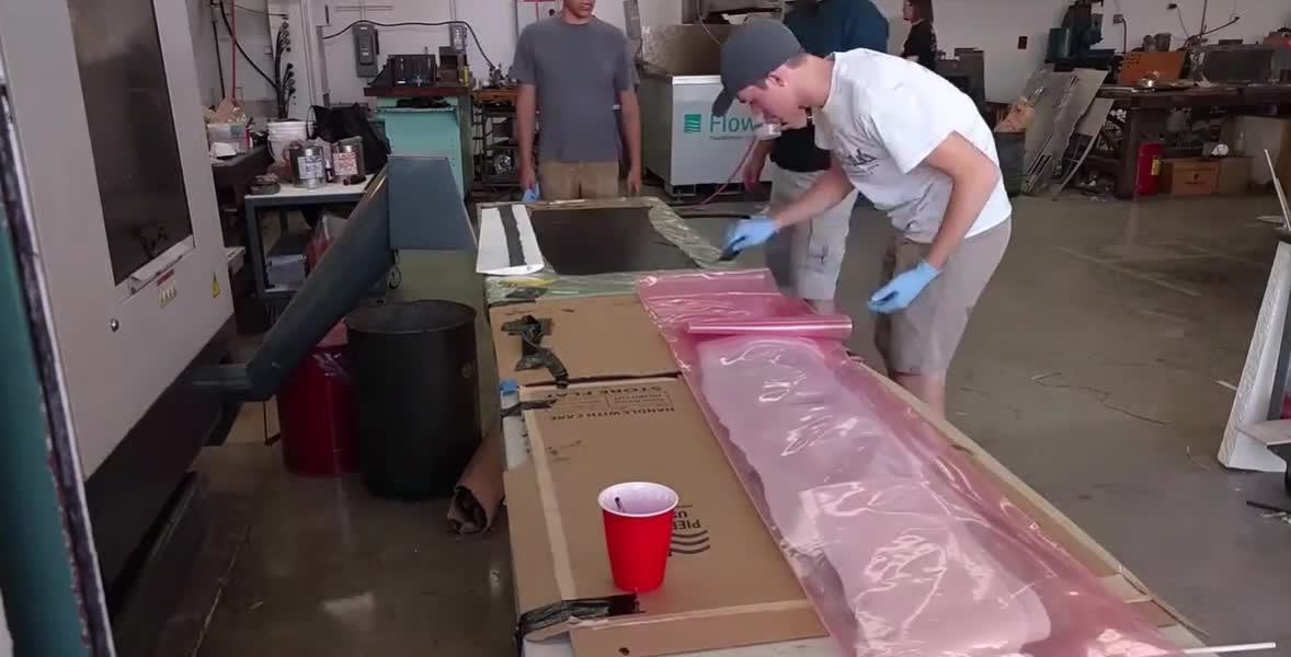 Technician applying resin by hand during wet layup