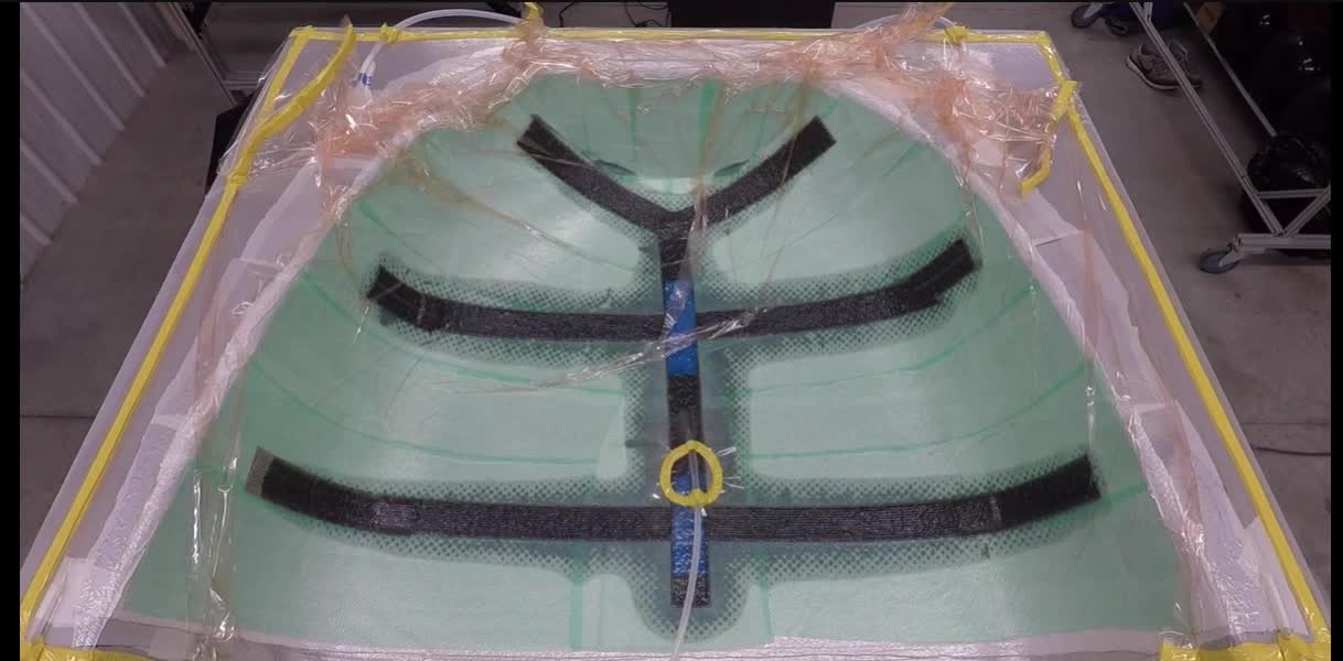 Composite part under vacuum bag with resin feed line